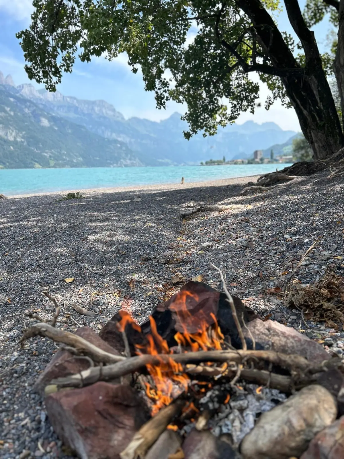 Lagerfeuer am Ufer des Walensees in der Abenddämmerung